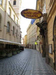 A cafe and theater line a pedestrian-only cobble street.